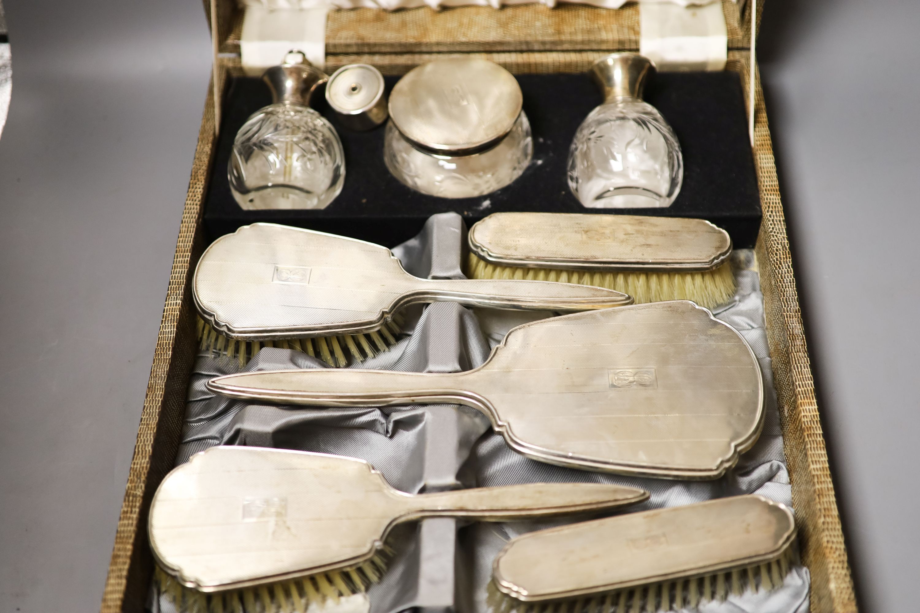 A late 1940's cased silver mounted eight piece dressing table set with atomiser, scent bottle and powder bowl.